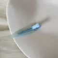 Vue détaillée d'une pince à cheveux triangulaire bleu clair mat avec texte gravé - Clip Triangulaire Sans Trace (FJ83071) / Bleu transparent