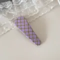 Vue détaillée d'une barrette à cheveux en tissu à carreaux violets et marron. - Checkered Teardrop Clip