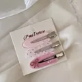 Detail of three pink acrylic duckbill hair clips with floral and bow patterns - Three-Piece Set / Pink