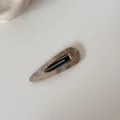Gros plan d'une pince à cheveux BB en tissu beige avec un élégant motif floral vintage - Clip Goutte d'Eau Ajouré / Café Floral