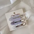 Detail view of three Korean style acrylic hair clips with floral and gingham patterns. - Three-Piece Set / Purple