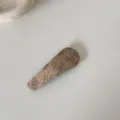 Vue détaillée d'une pince à cheveux BB en tissu fleuri vintage montrant la texture de la broderie - Barrette Goutte d'Eau / Café Floral