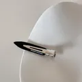 Gros plan d'une pince à cheveux noire minimaliste sans traces. - Noir