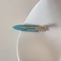 Détail macro d'une pince à cheveux en acétate bleu clair avec texte FRANCE Handmade blanc - Bleu lac