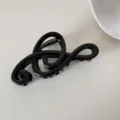 Detalle de una pinza para el pelo con forma de clave de sol en resina negra brillante - Música / Superficie Brillante Negra