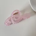 Detalle de una pinza para el pelo rosa translúcida con forma de nota musical - Música / Rosa Melocotón