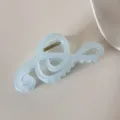 Detalle de una pinza para el cabello en forma de nota musical hecha de resina azul suave. - Música / Azul cielo
