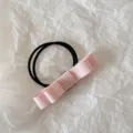Detailed view of a pink fabric bow hair tie with double-strand black elastic band - Deep Pink