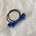 Close-up of blue double-layered fabric bow hair tie on textured white background - Dark Blue