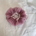 Makroansicht eines lila Mesh-Haargummis mit weißen Satinbändern im Ballett-Stil - Schleifen-Scrunchie / Rosa