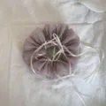 Detaillierte Ansicht eines staubig-violetten Mesh-Haargummis mit weißen Seidenbändern. - Schleifen-Scrunchie / Grau