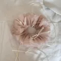 Detail eines staubrosa Mesh-Haargummis mit zarten cremefarbenen Bandschleifen - Schleifen-Scrunchie / Beige Aprikose