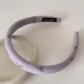 Gros plan d'un élégant serre-tête lavande avec des motifs de nœuds dessinés à la main - 2cm de Large / Violet