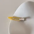 Détail d'une pince à cheveux jaune en acétate avec l'inscription FRANCE Handmade élégante - Jaune