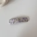 Détail d'une barrette en tissu lavande avec d'élégants motifs de feuilles violettes et olives - Pince carrée / Rose Racine de Lotus Floral