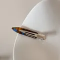 Gros plan d'une pince à cheveux en acétate écaille de tortue avec clip en métal argenté. - Glacé Marbré
