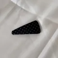 Vue détaillée d'une pince à cheveux triangulaire noire à pois blancs sur tissu - Grand triangle / Noir