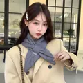 Close-up of a stylish grey quilted down scarf for women worn by a model in winter - 90cm / Gray