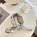 Detailed view of a striped linen neck scarf in a minimalist lifestyle setting - 55x55cm / Black & White Stripes