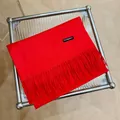 Detalle de una elegante bufanda de cachemira roja con flecos sobre mesa de cristal - 180cm / Rojo China