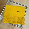 Vista detallada de una bufanda de cachemira amarillo vibrante con elegantes flecos - 180cm / Amarillo jengibre