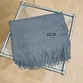 Detalle de una bufanda de cachemira gris suave con elegantes flecos sobre una mesa - 180cm / Gris Vigoré