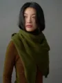 Nahaufnahme eines weichen olivgrünen Strickschals aus 100% Wolle an einem Modell - 166cm / Senfgrün