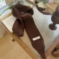 Primer plano de una bufanda de punto estrecha marrón oscuro con textura muy suave - 185x8cm / Marrón Mocha