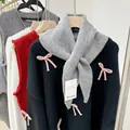 Close-up detail view of a soft grey wool knit triangle scarf accessory for women - Gray