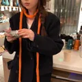 Vue détaillée d'une écharpe chenille en tricot orange vif et duveteuse sur un mannequin - Rouge Orangé
