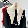 Versatile cream wool blend knitted triangle scarf and headscarf for women shown on a hanger - Off White