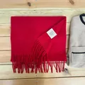 Detail view of premium 100% Australian wool red scarf with fringe and material label - Jujube Red