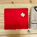 Close-up view of a red 100% Australian wool scarf showing the authentic material care label - Red