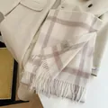 Detail view of a 100% wool plaid scarf featuring elegant fringes and a quality label - 180cm / Textured Rice White Plaid