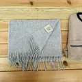 Close-up of 100% Australian wool scarf with fringed edges and material tag - Smoke