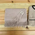 Detailed shot of a premium 100% Australian wool scarf featuring fringe and label - Dusty Mauve
