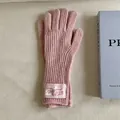 Close-up of pink knitted wool gloves with a vintage-style cloth label on the wrist. - One Size / Pink