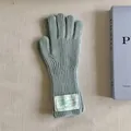 Detailed close-up showing the soft texture of mint green knitted wool gloves with label - One Size / Light Green