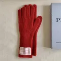 Detailed view of red ribbed knit wool gloves with a vintage white fabric wrist label - One Size / Atmospheric Red