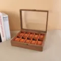 Vista detallada del joyero de nogal con 10 compartimentos y suaves cojines naranjas. - Grano de Madera Marrón Caja para 10 Relojes