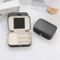 Portable black PU leather jewelry box featuring a built-in mirror and ring slots - Black