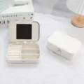Elegant white PU leather jewelry box featuring a built-in mirror and secure snap closure - White