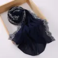 Detailed view of navy blue chiffon hijab featuring elegant white lace floral edges. - 180cm / Navy Blue
