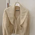 Detail view of a cream wool knit cardigan featuring a large shawl collar and bear decor. - 81cm / Oatmeal Beige