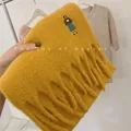 Close-up of mustard yellow wool blend scarf with embroidered character and fringe - Embroidered Girl / Turmeric