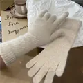 Detaillierte Nahaufnahme der Textur von weichen beigen langen Strickhandschuhen aus Wolle - Einheitsgröße / Gebrochenes Weiß