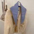 Detailed view of a solid blue knit triangular scarf draped over a fuzzy beige cardigan. - 81cm / Blue
