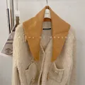 Close-up of mustard yellow wool blend triangular scarf paired with knit cardigan. - 81cm / Camel
