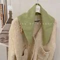 Close-up detail of a soft green wool blend knit triangle scarf styled on a beige cardigan - 81cm / Mint Green
