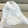 Detailed view of an elegant white silk-like scarf featuring pearls and mesh trim - 180cm / White